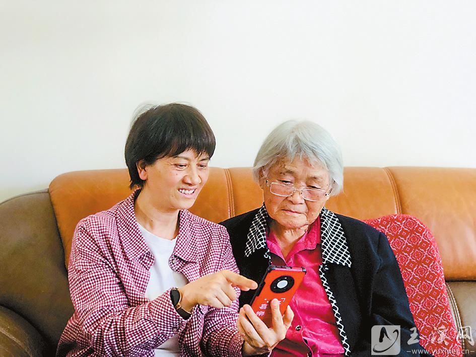 丁樹芬正在給90歲的老同志聶淑芬演示如何使用“學(xué)習(xí)強國”App。 （圖片由丁樹芬提供）