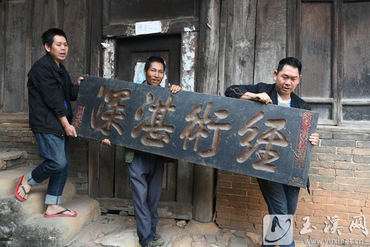 張耀文向游客展示自家珍藏的匾額。