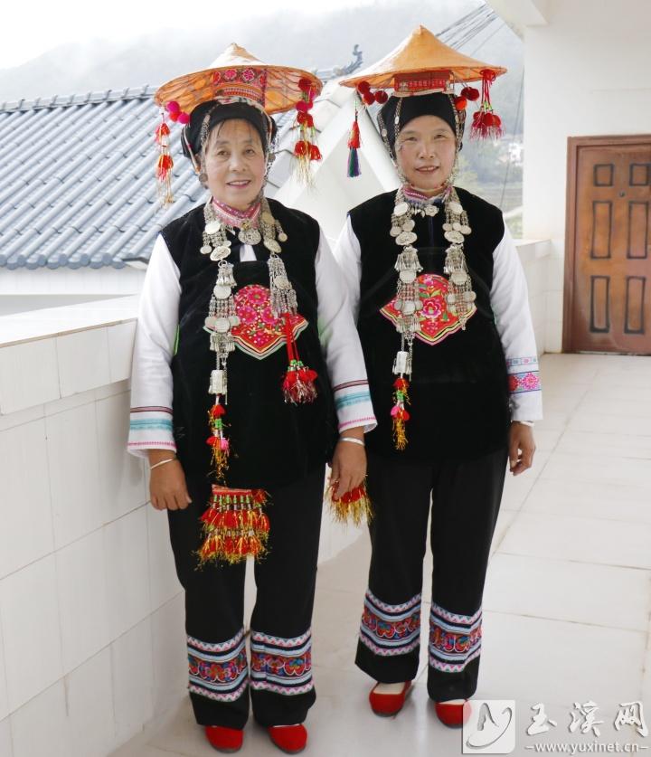 頭戴小葉蓮帽，內(nèi)穿白色長袖衫，外著黑色對襟小褂的彝族婦女。