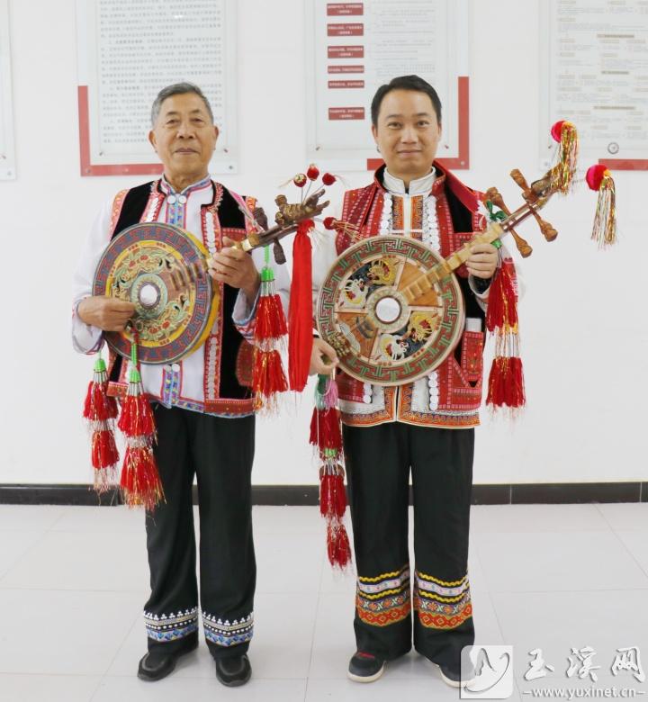 彝家男子身穿民族服飾彈四弦。