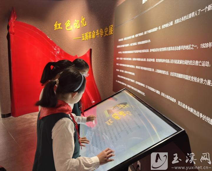 孩子們?cè)诩t色文化展館前駐足，了解玉溪的革命歷史。